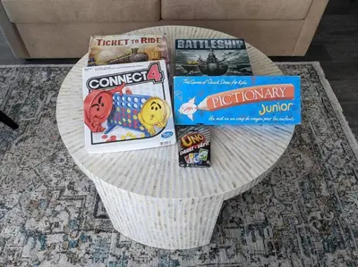 a table with books and games on it at Downtown King Suite-Surround Views-Pool/Gym/Parkng in Vancouver