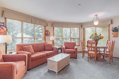 a living room with a couch and a table and chairs at The best ski in ski out two bedroom condo at Aspens in Whistler