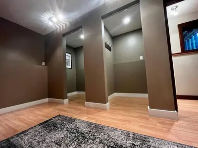 an empty living room with a rug on a wooden floor at Two Bedroom House by Snow Valley Lodging in Fernie
