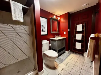 a bathroom with red walls and a toilet and a sink at Two Bedroom House by Snow Valley Lodging in Fernie