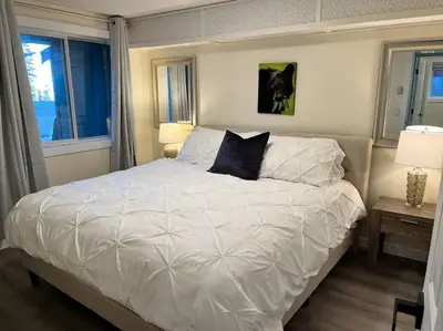 a bedroom with a large white bed with two pillows at Bearcub Chalet in Big White
