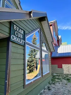 a sign on the side of a building with a bear cue chapel at Bearcub Chalet in Big White