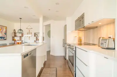 a kitchen with white counters and stainless steel appliances at Sunset Beach Walk 2BD+2BA+1PRK Yaletown in Vancouver