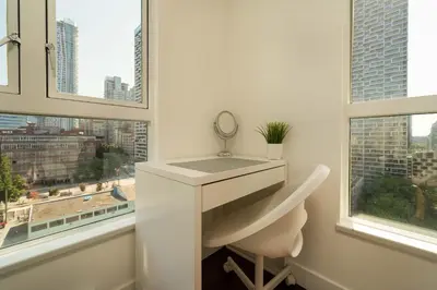 a bathroom with a sink and a mirror and windows at Sunset Beach Walk 2BD+2BA+1PRK Yaletown in Vancouver