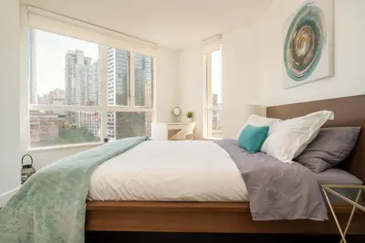 a bedroom with a large bed with a large window at Sunset Beach Walk 2BD+2BA+1PRK Yaletown in Vancouver