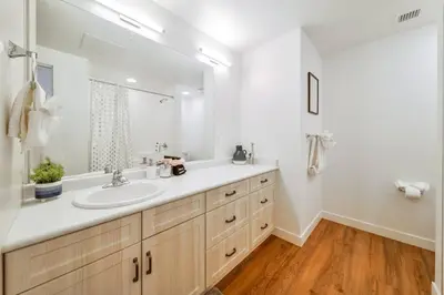 a white bathroom with a sink and a mirror at Royal Blue Wild Oasis Corner PNHSE KingBed U/G Wi-fi in Edmonton