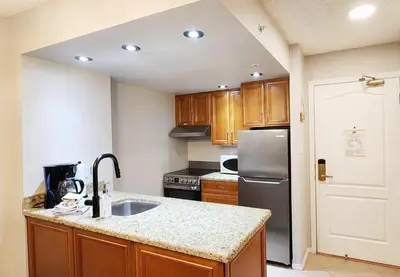 a kitchen with a sink and a refrigerator at 1BR in Marquise, Dog Friendly, Close to Ski Hill, Pool, Sauna, Hot Tub, Fitness Suite, AC in Whistler