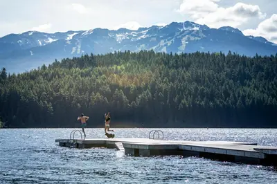 two people standing on a dock in the water at 1BR in Marquise, Dog Friendly, Close to Ski Hill, Pool, Sauna, Hot Tub, Fitness Suite, AC in Whistler
