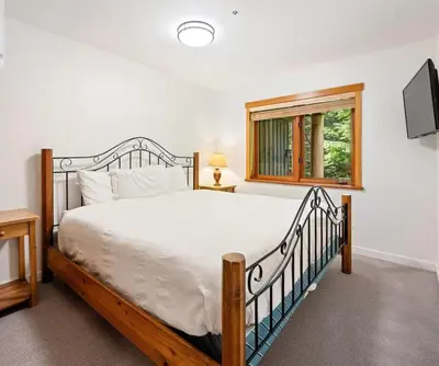 a bedroom with a large bed and a window at Ski In/Ski Out Luxury Home w/ jacuz/ fireplace in Whistler