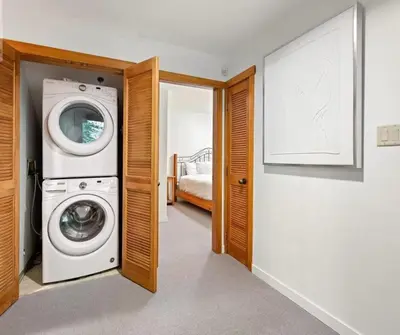 a washer and dryer in a room with a bedroom at Ski In/Ski Out Luxury Home w/ jacuz/ fireplace in Whistler