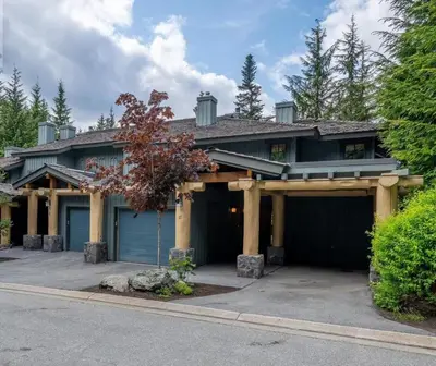 a house with a blue garage at Ski In/Ski Out Luxury Home w/ jacuz/ fireplace in Whistler