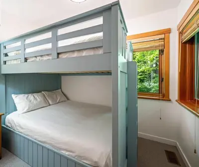 a bedroom with a bunk bed and a window at Ski In/Ski Out Luxury Home w/ jacuz/ fireplace in Whistler