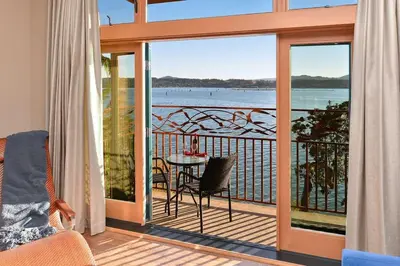 a room with a balcony with a view of the water at Salishan Chief Suite by EMR Vacation Rentals in Cowichan Bay