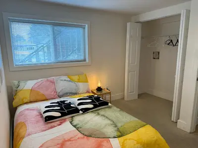 a bedroom with a colorful bed with a window at Private room in a Shared house in Vancouver