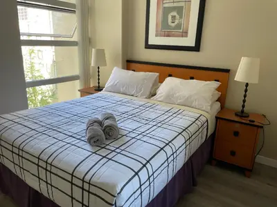 a bedroom with a bed with two towels on it at 1BD+Den condo, with free parking in Downtown! in Vancouver