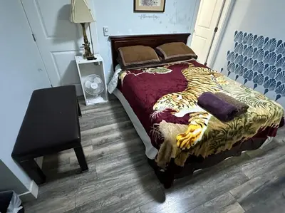 a bedroom with a bed and a table with a lamp at Guest Suite - Private Retreat - J-1 in Abbotsford