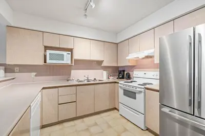a kitchen with a white refrigerator and a sink at Powderhorn by Whistler Premier in Whistler