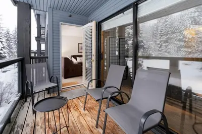 a room with chairs and a living room with snow at Powderhorn by Whistler Premier in Whistler