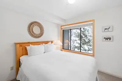 a bedroom with a white bed and a window at Powderhorn by Whistler Premier in Whistler