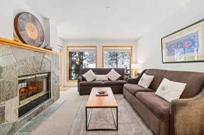 a living room with a couch and a fireplace at Powderhorn by Whistler Premier in Whistler