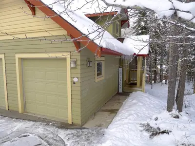 a house with a garage in the snow at Aurora Townhomes by StayIn in Panorama