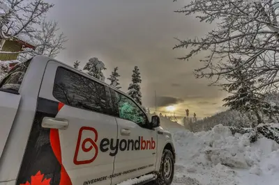 a white van parked on a snow covered road at Aurora Townhomes by StayIn in Panorama