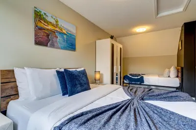 a bedroom with a large white bed with blue pillows at Amazing mountain views 1bd Apartment Canmore Banff in Canmore