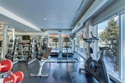 an image of a gym with treadleys and ellipticals at Chateau Canmore in Canmore