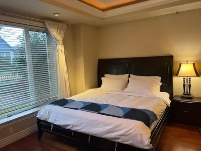 a bedroom with a bed and a window at Lucky suite, two-bedroom suite with independent entrance in Richmond close to YVR in Richmond