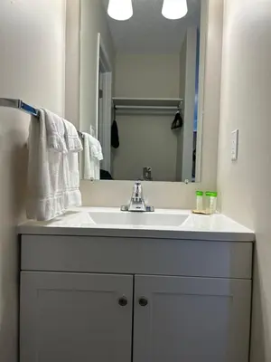 a bathroom with a white sink and a mirror at Anavada Inn & Suites - Grande Prairie in Grande Prairie