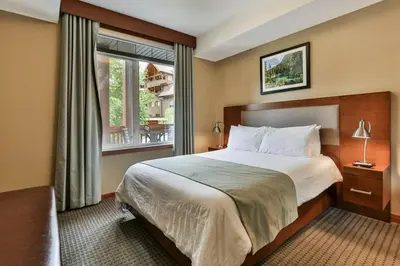 a hotel room with a large bed and a window at Luxury Falcon Crest Lodge 1 Bedroom 1 Pullout Kitchen Hot Tub in Canmore