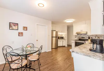 a kitchen and dining room with a glass table and chairs at Southgate 5 Bedroom Vacation Home with Double Garage in Edmonton