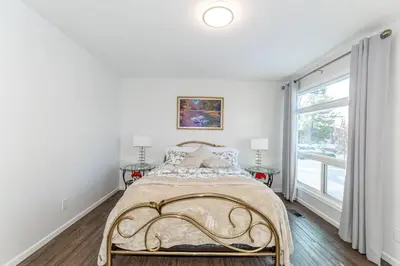 a white bedroom with a bed and a window at Southgate 5 Bedroom Vacation Home with Double Garage in Edmonton