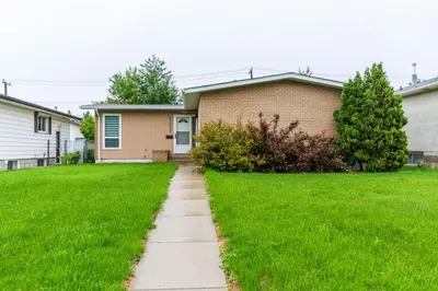 a house with a sidewalk in front of a yard at Southgate 5 Bedroom Vacation Home with Double Garage in Edmonton