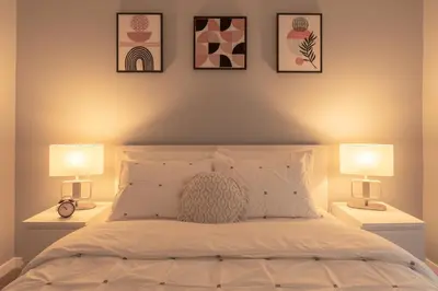 a bedroom with a bed with two lamps on it at You will love this 2BR Guest Suite in SE Calgary in Calgary