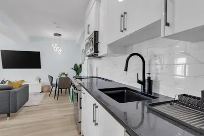 a kitchen with a sink and a living room at You will love this 2BR Guest Suite in SE Calgary in Calgary