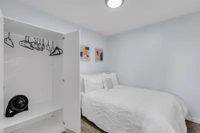 a white bedroom with a white bed and a white wall at You will love this 2BR Guest Suite in SE Calgary in Calgary