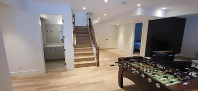 a living room with a table and a stair case at Fernie Escape - Mountain Home on the Ski Hill in Fernie