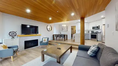 a living room with a couch and a table and a kitchen at Ironwoods on Blueberry Hill by Whistler Blackcomb Vacation Rentals in Whistler