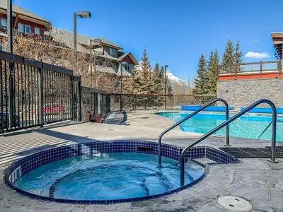 a hot tub in a patio next to a building at Beautiful Renovated Wolf 2Bed 2Bath in Canmore