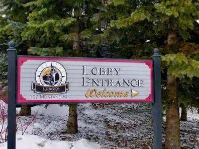 a sign for a library entrance in the snow at Beautiful Renovated Wolf 2Bed 2Bath in Canmore