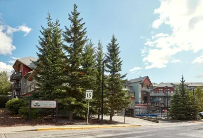a street with pine trees in front of condos at Beautiful Renovated Wolf 2Bed 2Bath in Canmore