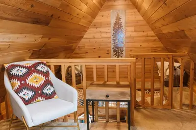 a room with a chair and a wooden ceiling at The Kootenay Lake House - A Private Luxury Retreat in Nakusp