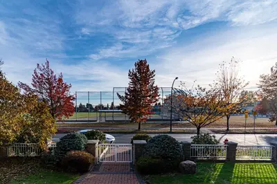 a fence in a park with trees and a street at \u6e29\u897f\u533a\u8c6a\u534e\u522b\u5885\u9644\u6709\u6309\u6469\u6d74\u7f38\u94a2\u7434\uff0c\u63a5\u8fd1\u673a\u573adowntown in Vancouver