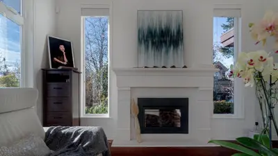 a living room with a fireplace and a chair at \u6e29\u897f\u533a\u8c6a\u534e\u522b\u5885\u9644\u6709\u6309\u6469\u6d74\u7f38\u94a2\u7434\uff0c\u63a5\u8fd1\u673a\u573adowntown in Vancouver