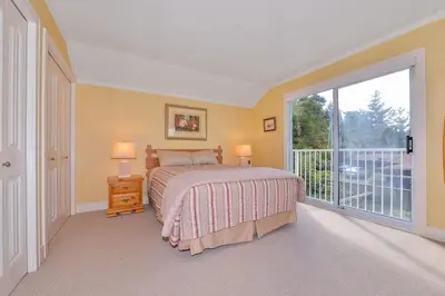 a bedroom with a bed and a large window at Kye Bay Winter Beach House by EMR Vacation Rentals in Comox