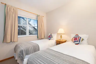 two beds in a room with a window at Deer Run by Whistler Premier in Whistler