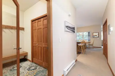 a hallway with a door leading to a dining room at Deer Run by Whistler Premier in Whistler