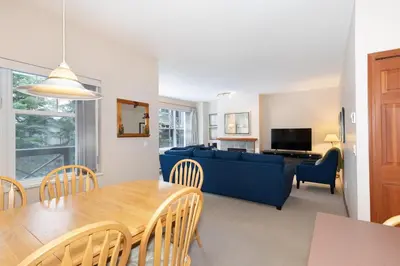 a living room with a blue couch and a table at Deer Run by Whistler Premier in Whistler
