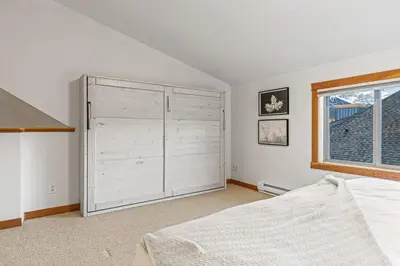 a bedroom with a large white closet and a window at Attractive Downtown Condo! Hot Tub, Mountain Views managed by Little Sister Getaways in Canmore